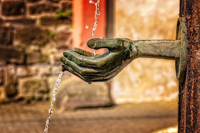 Exposed To Contaminated Water A hand is pouring water from a fountain at Camp Lejeune, known for its contaminated water.