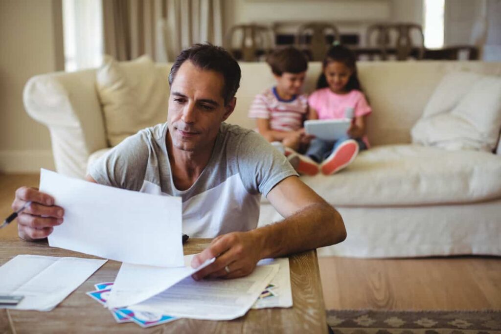 Man holding a bill in living room difference between ssi and ssdi