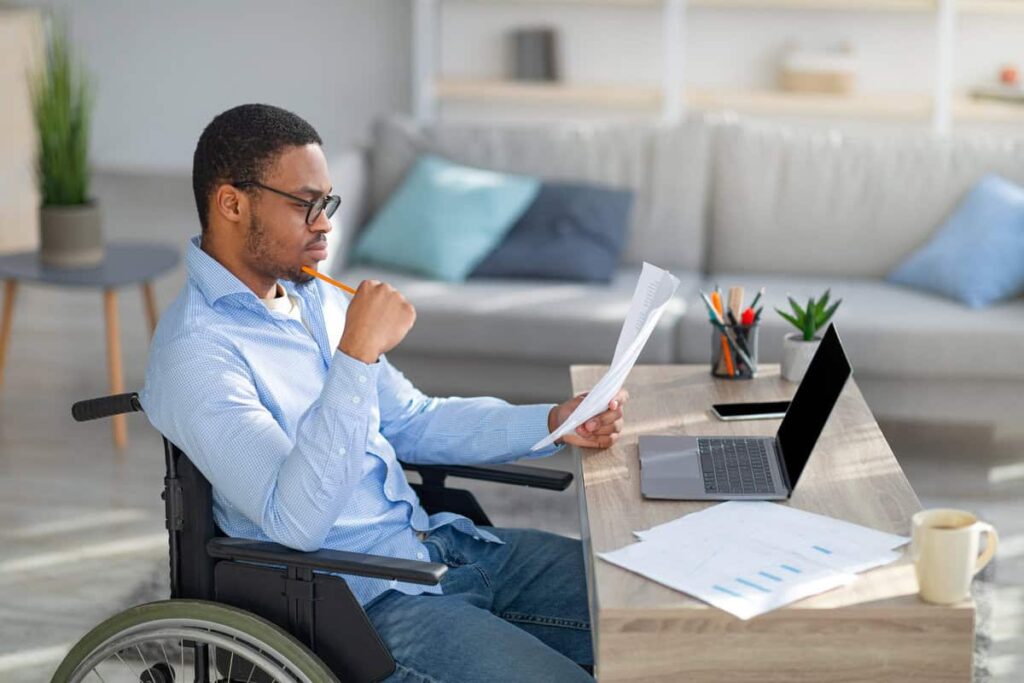 focused-black-disabled-man-in-wheelchair-working-w-2023-11-27-04-51-01-utc1 Find Out What Conditions Automatically Qualify You For Disability In 2023