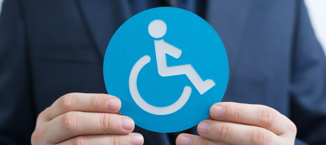 Icon of the person with disabilities made of paper in the hands of a man Social Security Disability Benefits Pay Chart 2026
