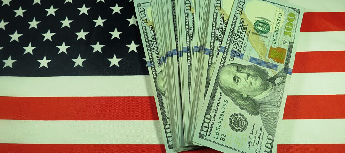 American dollars on national flag background, closeup